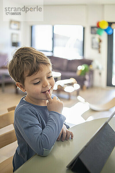 Junge benutzt digitales Tablet beim Online-Unterricht zu Hause