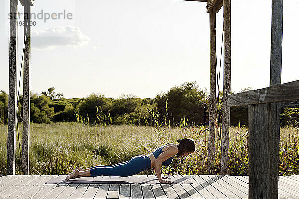 Frau macht Yoga am Pavillon