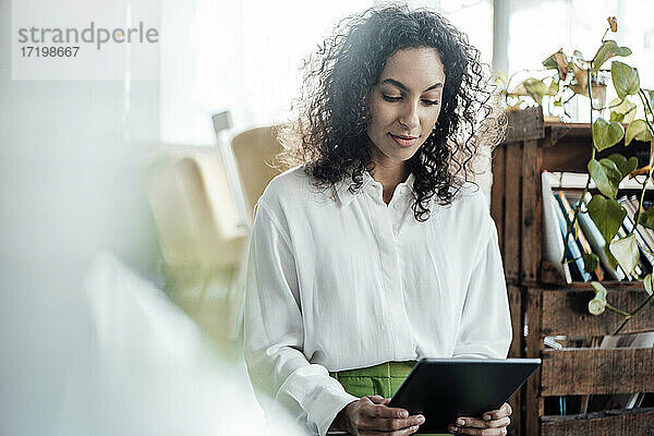 Junge Geschäftsfrau  die ein digitales Tablet benutzt  während sie in einem Café sitzt