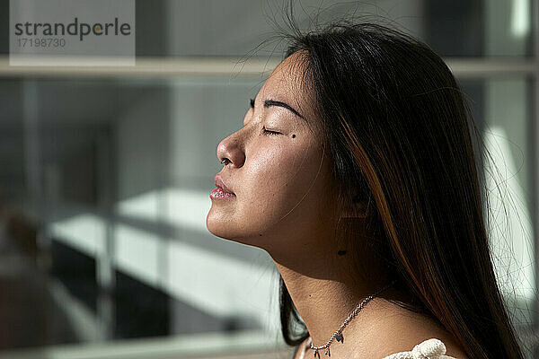 Junge Frau träumt im Freien an einem sonnigen Tag
