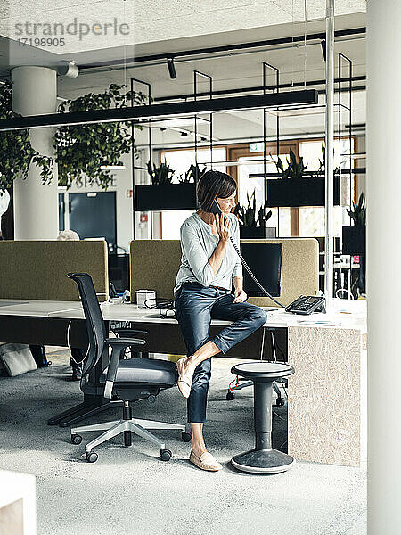 Weibliche Unternehmerin beim Telefonieren im Büro