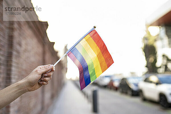 Hand hält LGBTQI-Regenbogenflagge