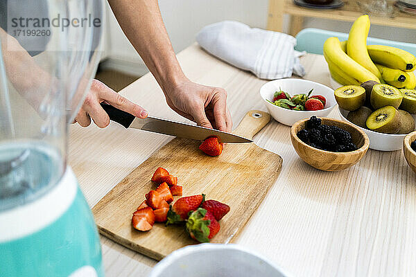 Mann schneidet frische Erdbeeren in der Küche