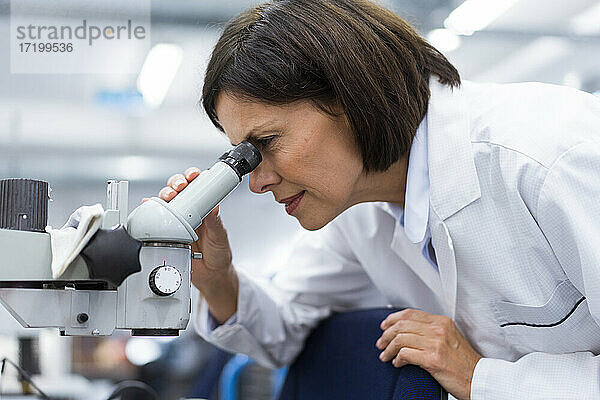Wissenschaftlerin mit Mikroskop bei der Arbeit im Labor