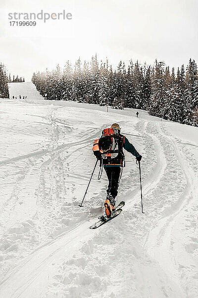 Kaukasischer älterer Mann beim Skifahren auf Schnee im Urlaub