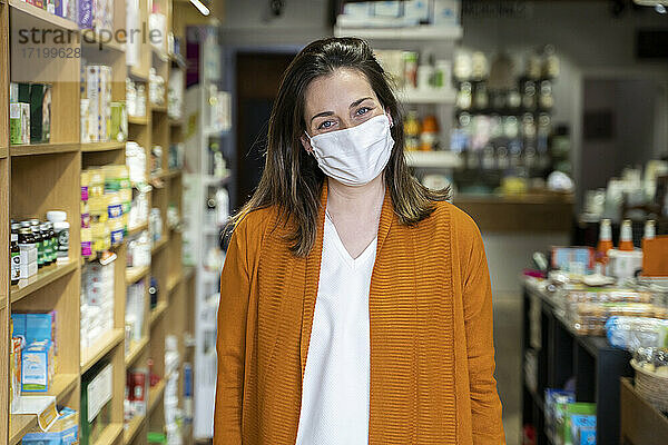 Junge Frau mit Gesichtsschutzmaske in einem Lebensmittelladen