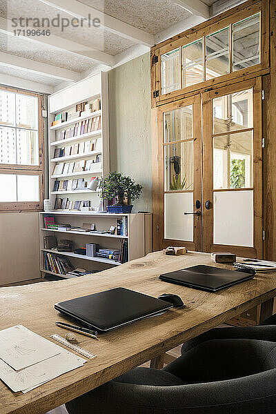 Laptops auf einem Holztisch in einem Büroraum in einer Werkstatt