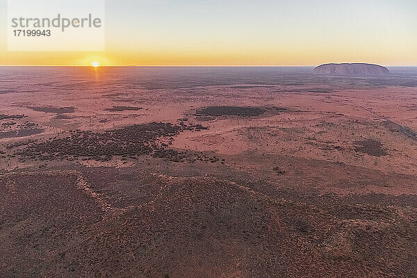 Australien  Northern Territory  Luftaufnahme der Wüstenlandschaft des Uluru-Kata Tjuta National Park bei Sonnenaufgang mit Uluru im Hintergrund