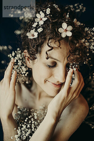 Lächelnde Frau mit weißen Blumen im Haar