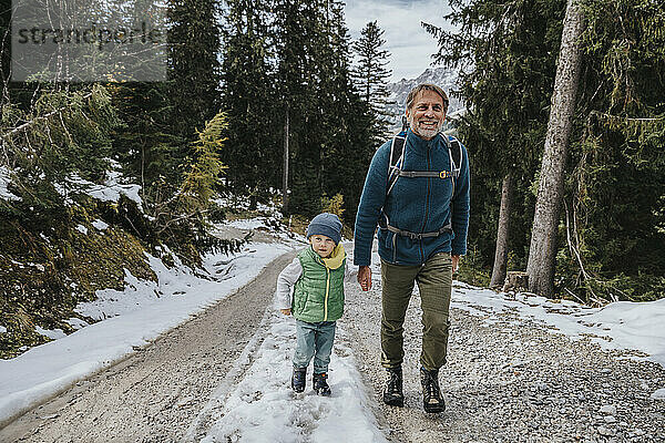 Junge mit lächelndem Vater beim Wandern im Wald im Salzburger Land  Österreich