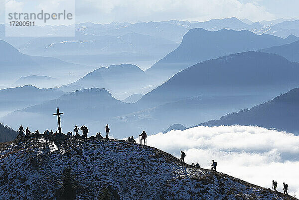 Grenzgebiet Österreich-Deutschland  Heuberg  Silhouetten von Rucksacktouristen beim Wandern zum Berggipfel