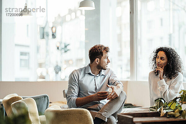 Geschäftsmann bespricht sich mit einem Kollegen bei einem Kaffee in einem Café