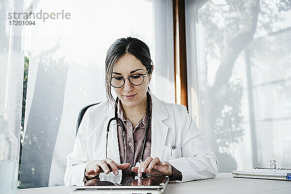 Ärztin bei der Arbeit an einem digitalen Tablet im Krankenhaus