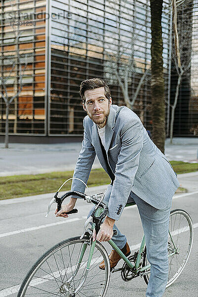 Geschäftsmann mit Fahrrad auf dem Fußweg in der Stadt stehend