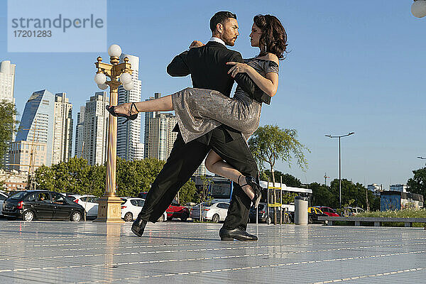 Männliche und weibliche Tänzer sehen sich beim Tangotanzen auf dem Fußweg an