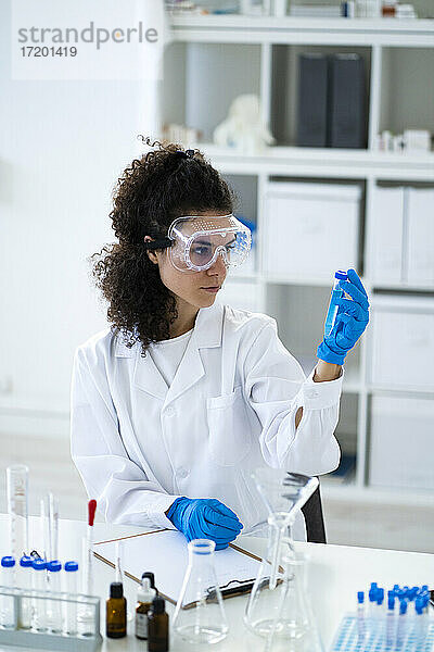 Wissenschaftlerin bei der Analyse einer chemischen Lösung im Reagenzglas im Labor