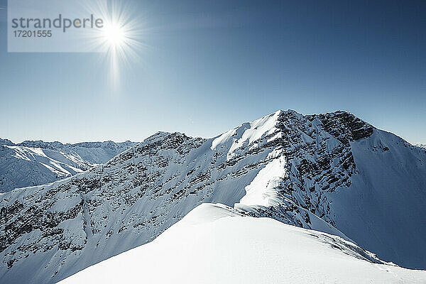 Sonnenstrahl über schneebedecktem Berg  Lechtaler Alpen  Tirol  Österreich
