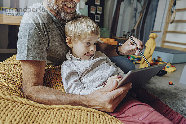 Vater hilft seinem Sohn beim E-Learning auf dem Tablet zu Hause