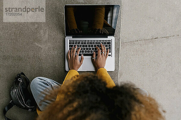 Afro-Frau mit Laptop im Sitzbereich