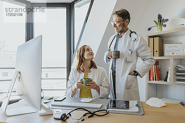 Lächelnde Ärzte bei einem Kaffee im Büro