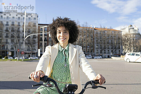 Afro junge Frau mit Elektrofahrrad in der Stadt