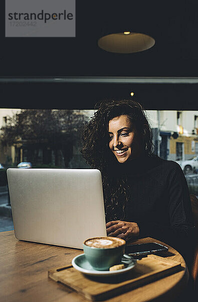 Geschäftsfrau mit Laptop in einem Café sitzend