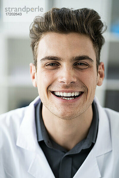 Männlicher Wissenschaftler lächelt im Labor