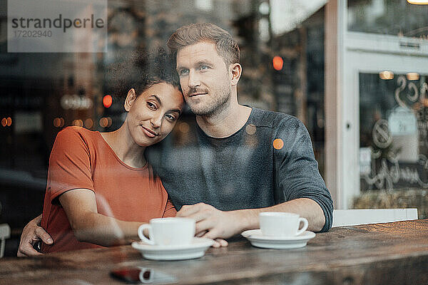 Paar schaut weg  während es zusammen im Café sitzt