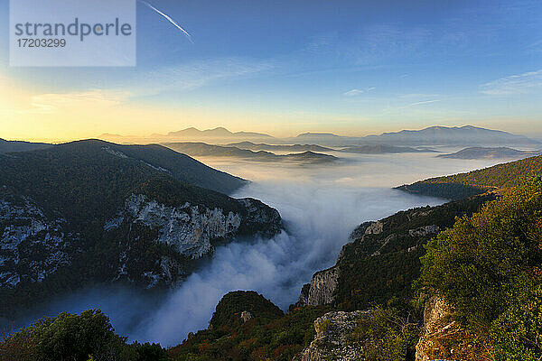 In Nebel gehüllte Berge vor blauem Himmel bei Sonnenaufgang in der Furlo-Schlucht  Marken  Italien