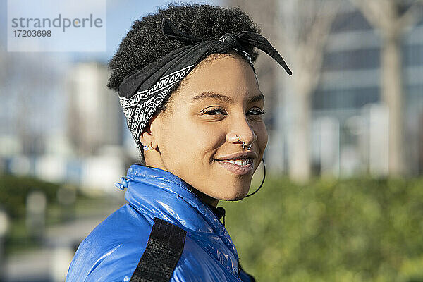Glückliche junge weibliche Hipster lächelnd im Freien an einem sonnigen Tag