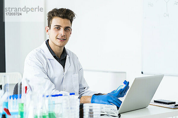 Männlicher Wissenschaftler mit Laptop bei der Arbeit im Labor