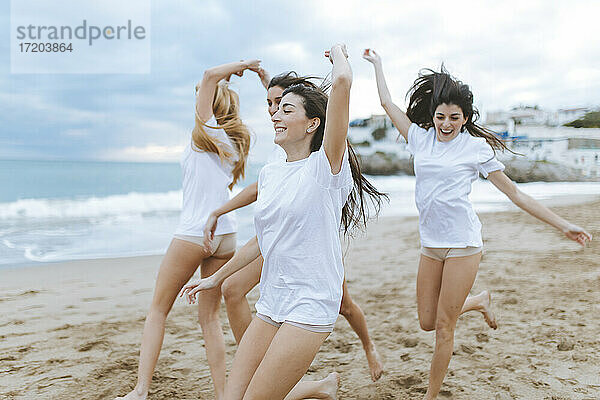 Fröhliche Freundinnen  die sich in den Ferien am Strand vergnügen