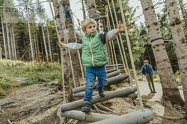 Junge schaut beim Hochseilgarten im Wald im Salzburger Land  Österreich  weg