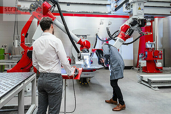 Männer bei der Prüfung von Robotern in der Fabrik