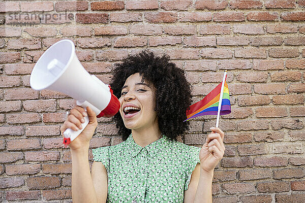 Gemischtrassige Frau  die für LGBTQI-Rechte gegen eine Mauer protestiert