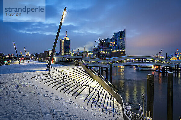 Deutschland  Hamburg  Elbpromenade in der Abenddämmerung mit Elbphilmarmonie im Hintergrund