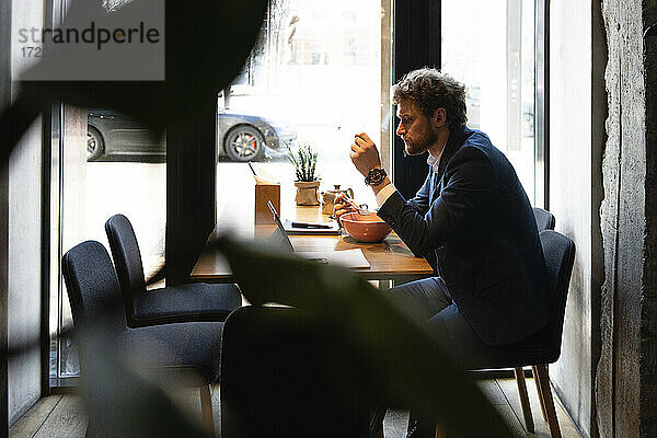 Geschäftsmann beim Essen im Café sitzend
