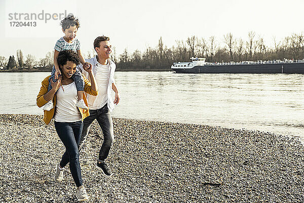 Glückliche Familie beim Laufen auf dem Kieselstein in den Ferien