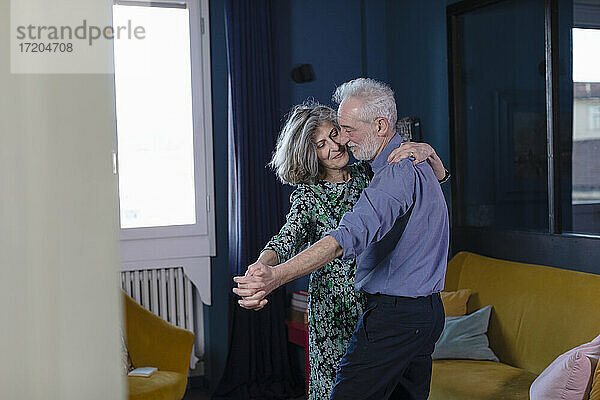 Älteres Paar tanzt im Stehen zu Hause