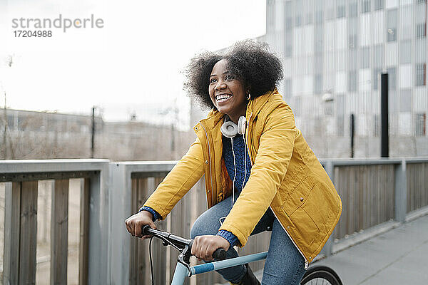 Lächelnde Frau beim Radfahren auf dem Fußweg