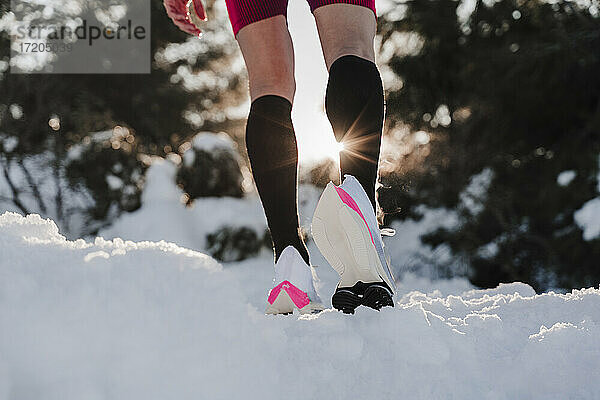 Sportler bei Sonnenuntergang auf schneebedecktem Land stehend
