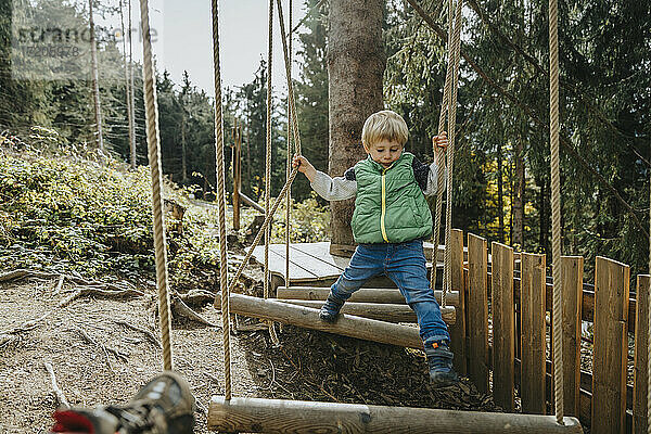 Junge im Hochseilgarten im Wald im Salzburger Land  Österreich