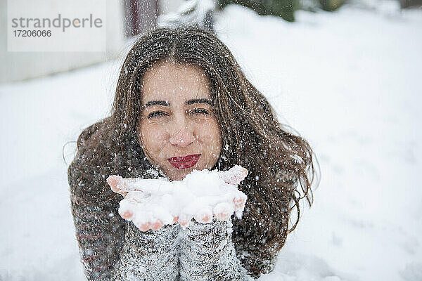 Schöne Frau beim Schneeräumen im Winter