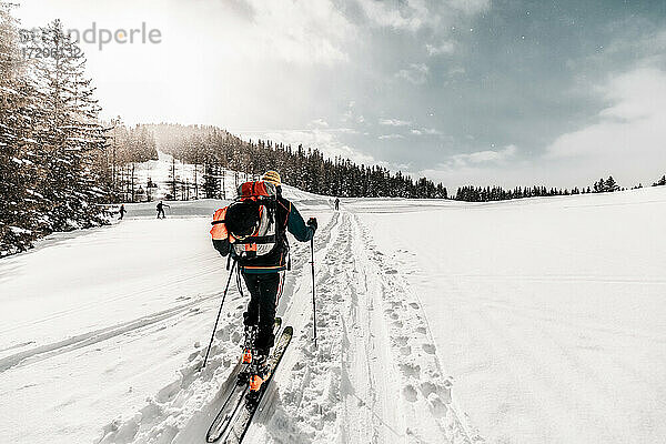 Aktiver älterer Mann beim Skifahren auf verschneitem Land im Urlaub