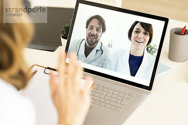 Ärztin bespricht sich mit Kollegen über ein digitales Tablet in einer medizinischen Klinik
