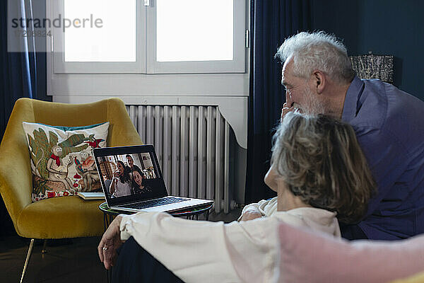 Älteres Ehepaar unterhält sich zu Hause mit der Familie per Videoanruf auf dem Laptop