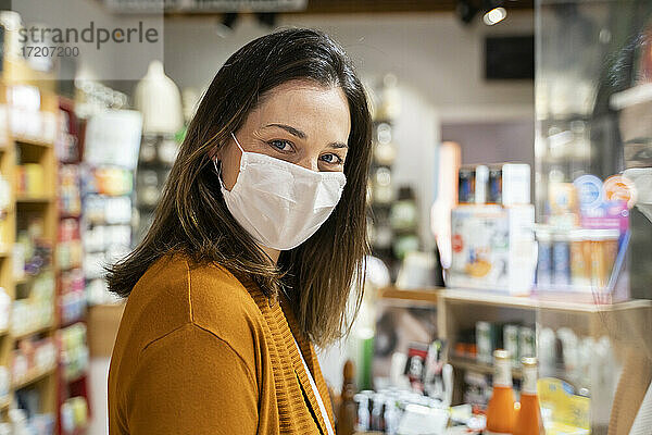 Junge Frau mit Schutzmaske in einem Lebensmittelgeschäft während einer Pandemie