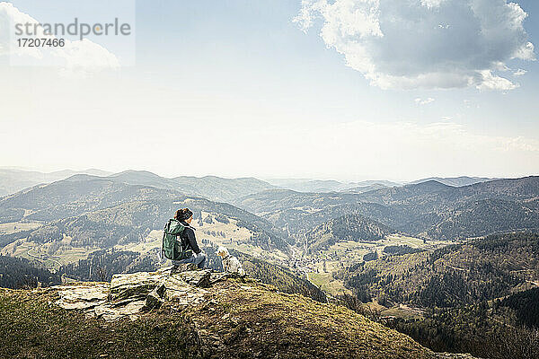 Wanderin mit Blick auf die Aussicht  während sie auf dem Kandel in Baden-Württemberg  Deutschland  sitzt