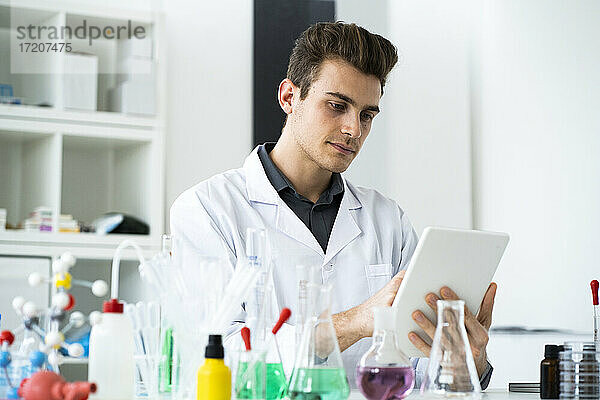 Männlicher Wissenschaftler benutzt ein digitales Tablet bei der Arbeit im Labor
