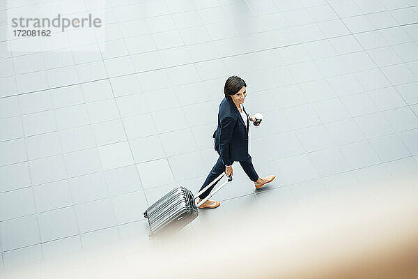 Geschäftsfrau mit Koffer im Korridor